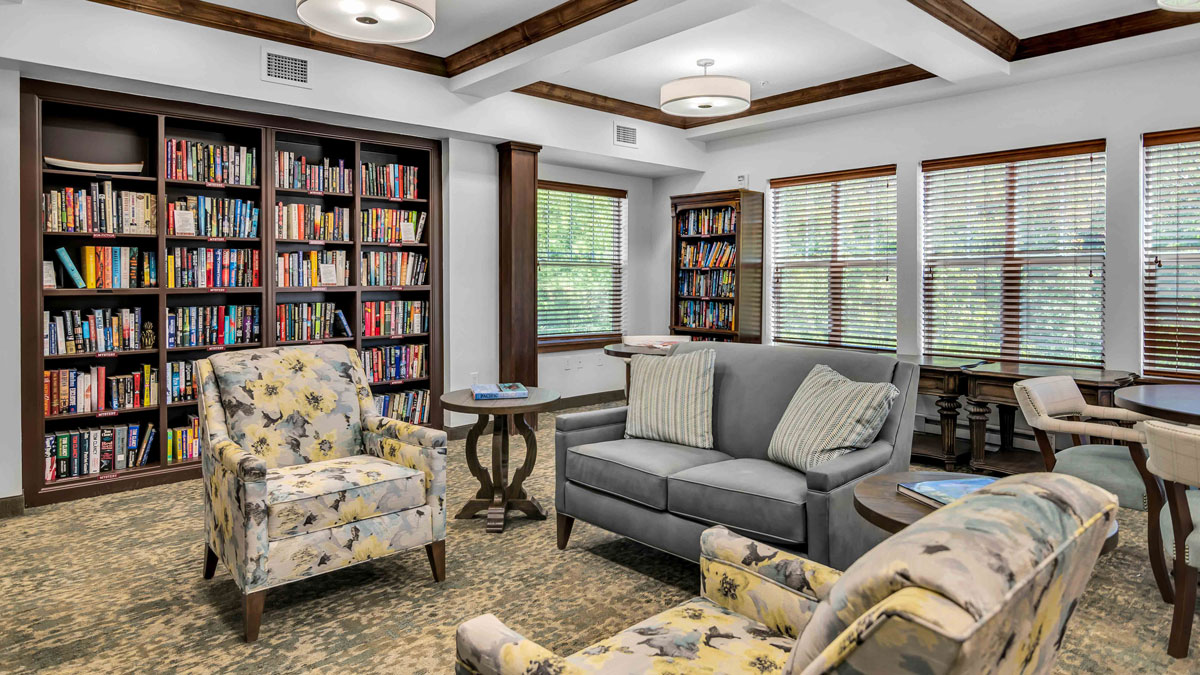 The library at The Highlands with shelves of books and comfortable seating