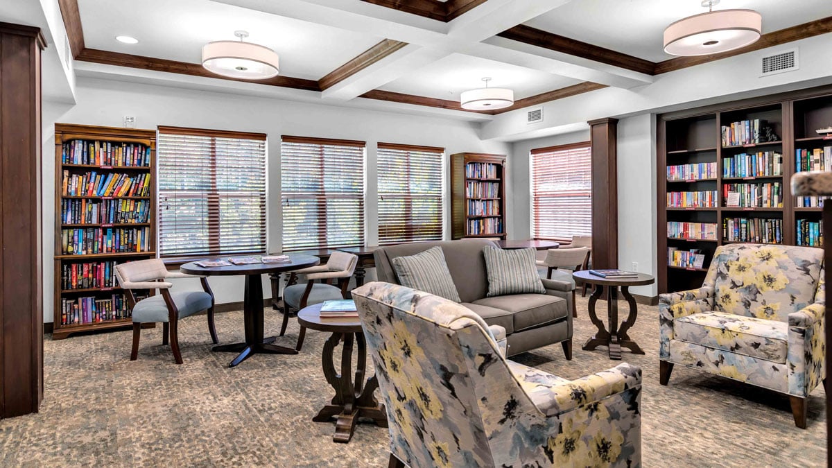 The library at The Highlands with shelves of books and comfortable seating